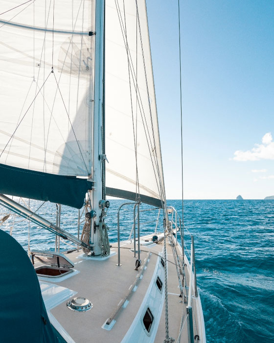 Vista de la proa de un barco de vela desde la cubierta, con el mar al fondo