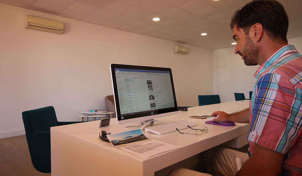 Hombre trabajando en un ordenador en una mesa de oficina