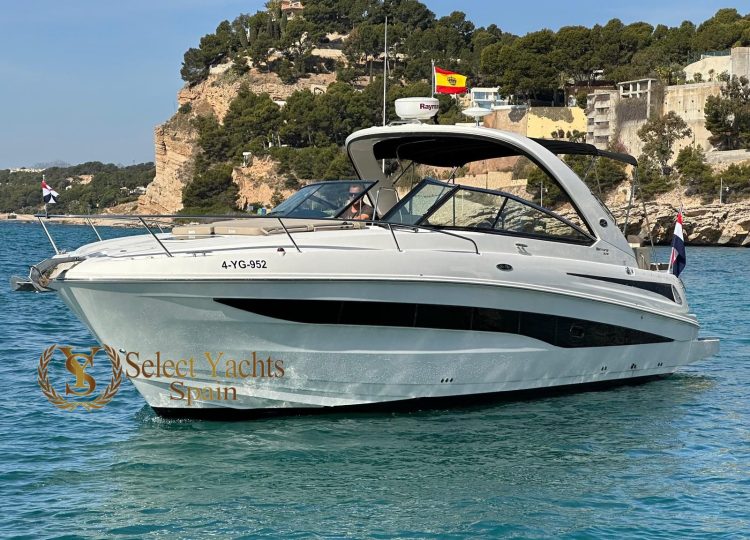 Un yate pequeño a motor en el agua frente a la costa de Altea